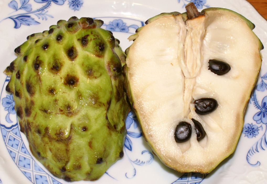 Atemoya fruit cut in half showing white flesh and black seeds