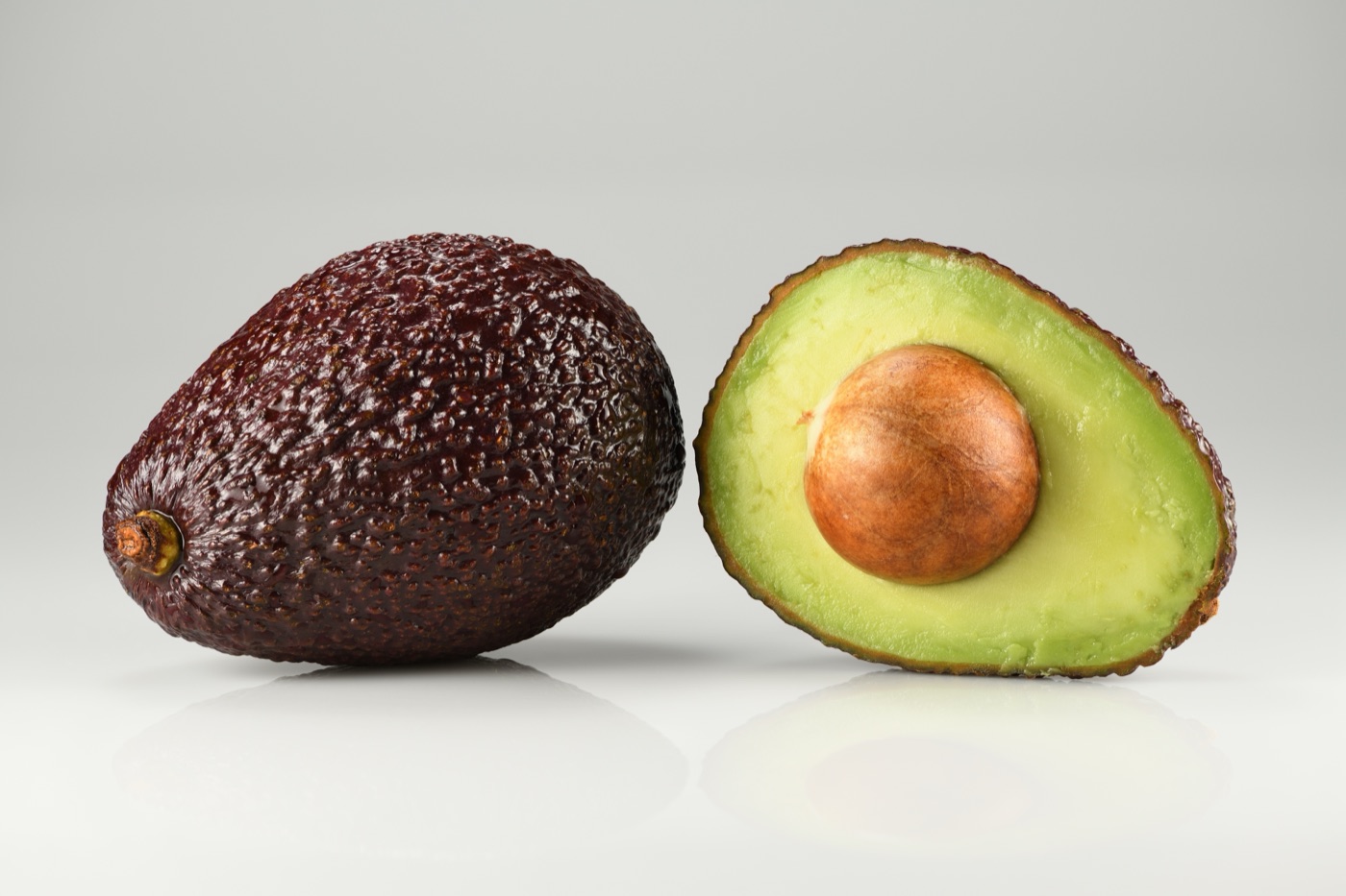Whole and halved Hass avocado